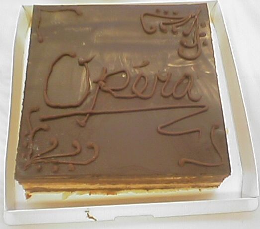 チョコレートの茶色に包まれた正方形のケーキ。表面には「Opéra」と書いてある。